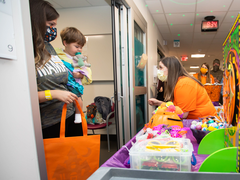 Child Life Specialist Morgan Flournoy brings Halloween surprises to Children's of Mississippi patient William Haraughty of McComb.