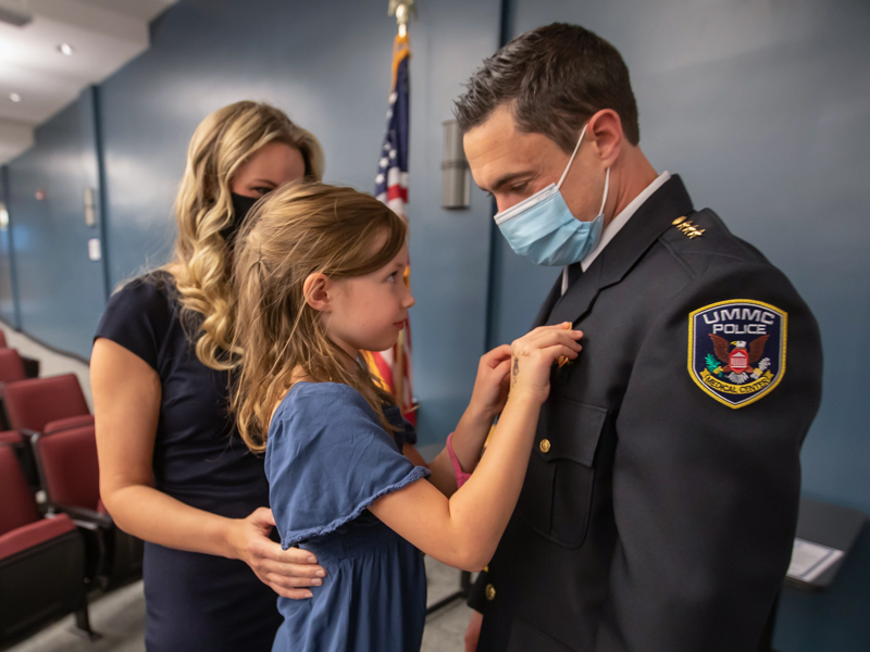 Bromen is pinned by his daughter, Victoria, as his wife, Paige, looks on following his swearing in.