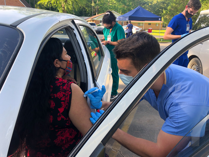 Maura Gabriel receives a COVID vaccination from second-year medical student Chandler Winstead during a May 22, Jackson Free Clinic outreach event in Forest.