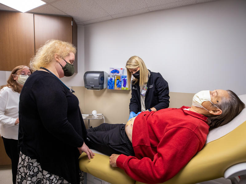 Dr. Laura Smart examines the abdomen of liver and kidney transplant patient Robert Jacobson. She's joined by abdominal transplant coordinator Taylor Tadlock, center, and Jacobson's wife Valerie.