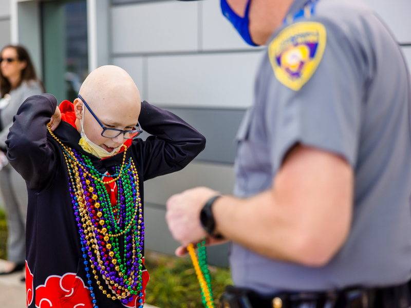 Children's of Mississippi patient Ryder Jackson of Long Beach puts on his Mardi Gras beads during a Department of Public Safety celebration at the children's hospital Thursday.