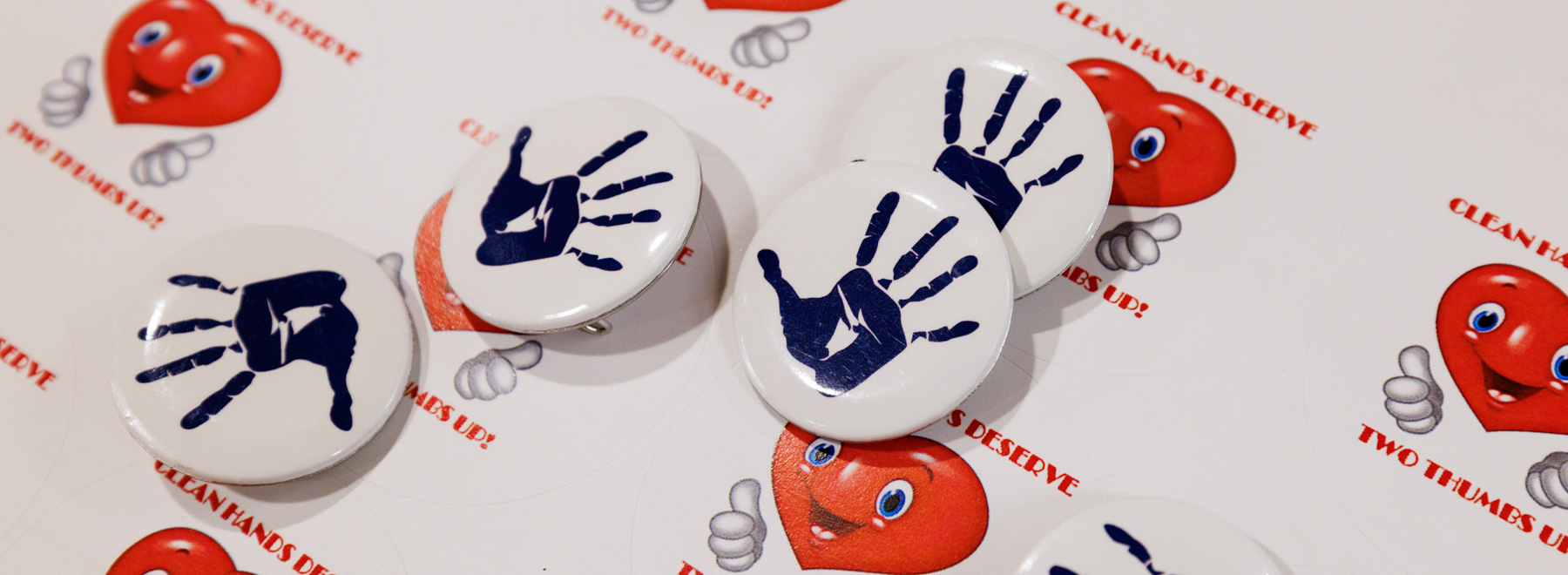 Pins and stickers remind everyone of hand hygiene's importance.