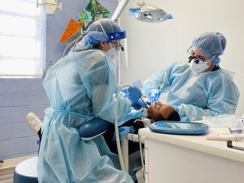 Rachel F. Hill, left, and Jenna Dunaway, fourth-year dental hygiene students, provide Willie Nolan of Port Gibson with a dental cleaning. (Photo courtesy of JFC/JoJo Dodd)