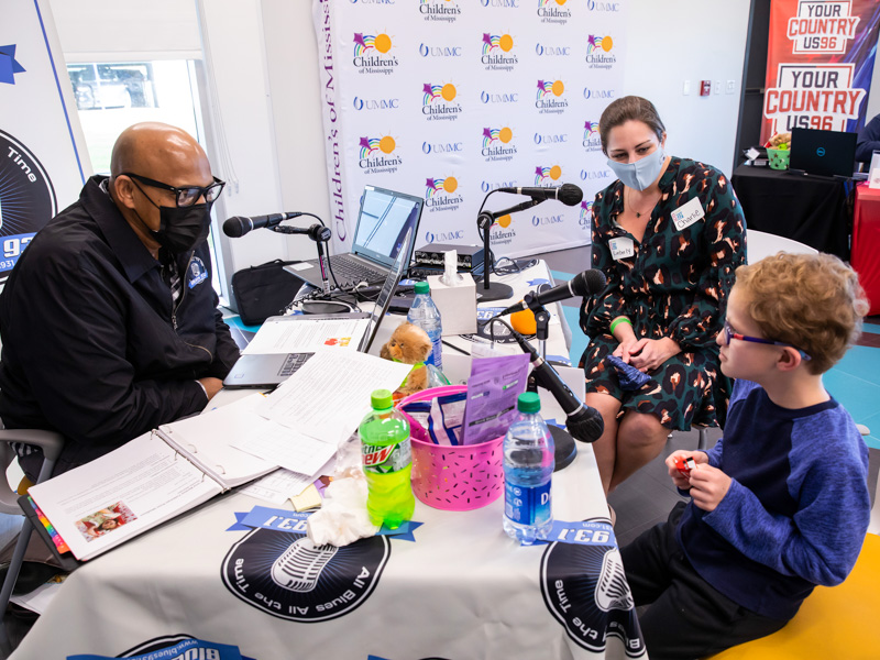 On-air personality Tyrone Davis of Blues 93.1 interviews Children's of Mississippi patient Charlie Cleland and his mom, Kimberly, in 2021.