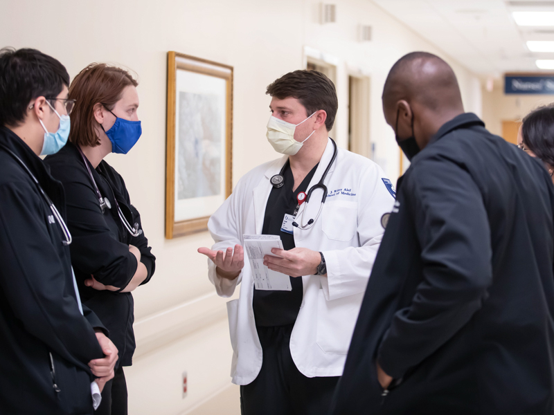 Scholarship recipient Riley Alef, center, and a trio of other medical students discuss patient care with internal medicine resident Dr. Danielle Foster, second from left, on 5 South.