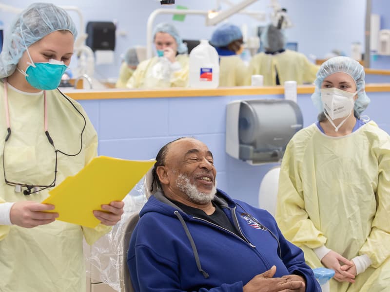 U.S. Army veteran Curtis Spencer answers screening questions from fourth-year dental hygiene student Rachel Hill, left, and third-year dental hygiene student Madeline Guest.