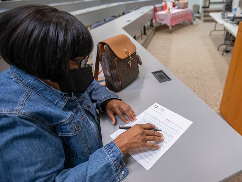 Patient Gwendolyn Johnson fills out paperwork before getting a dental procedure during Dental Mission Week.