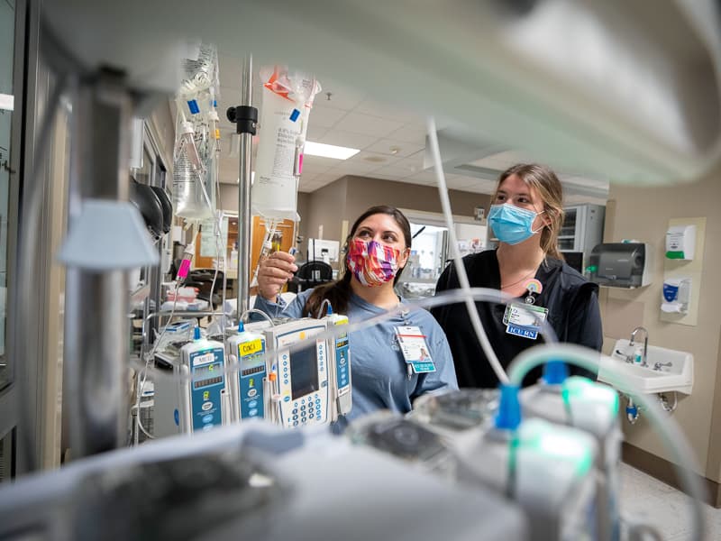 Registered nurse Mellisa Collins checks equipment and medications outside the room of a patient in the Medical ICU.