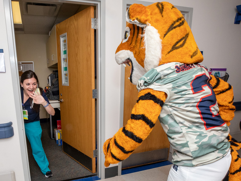 Social worker Kara Massie gets a surprise greeting from Sonny Thee Tiger of Jackson State University. Jay Ferchaud/ UMMC Communications