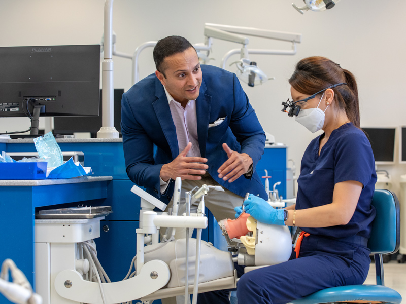 Dr. Shalin Patel visits with dental student Joanna Seo Han.