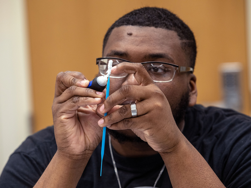 Jamarius Waller was one of many students who helped assemble COVID-19 test kits in March 2020. Jay Ferchaud/ UMMC Communications