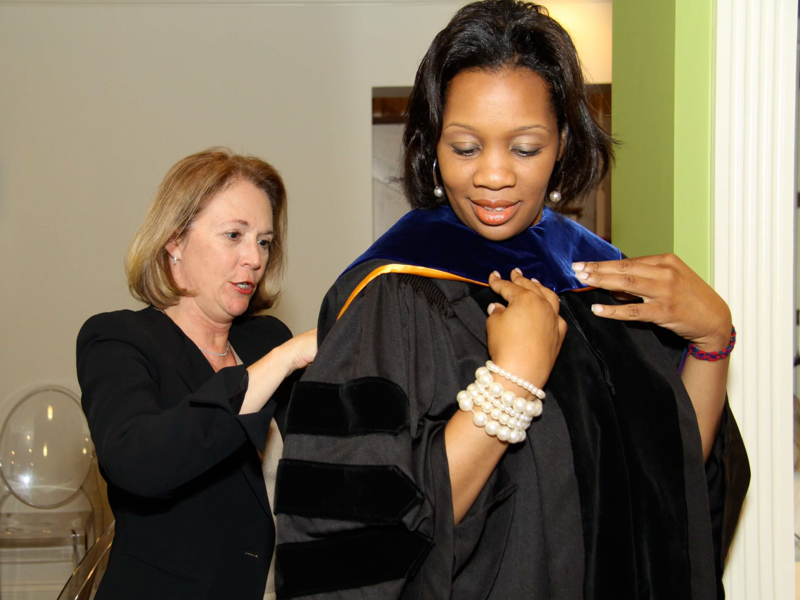 Bailey "hoods" Dr. Juanyce Taylor in front of her grandparents at her 2012 graduation party.