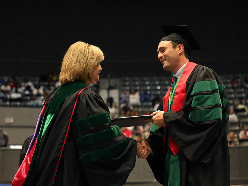 JoJo Dodd receives his MD from Dr. LouAnn Woodward, vice chancellor for health affairs and dean of the School of Medicine. Dodd was class marshal.