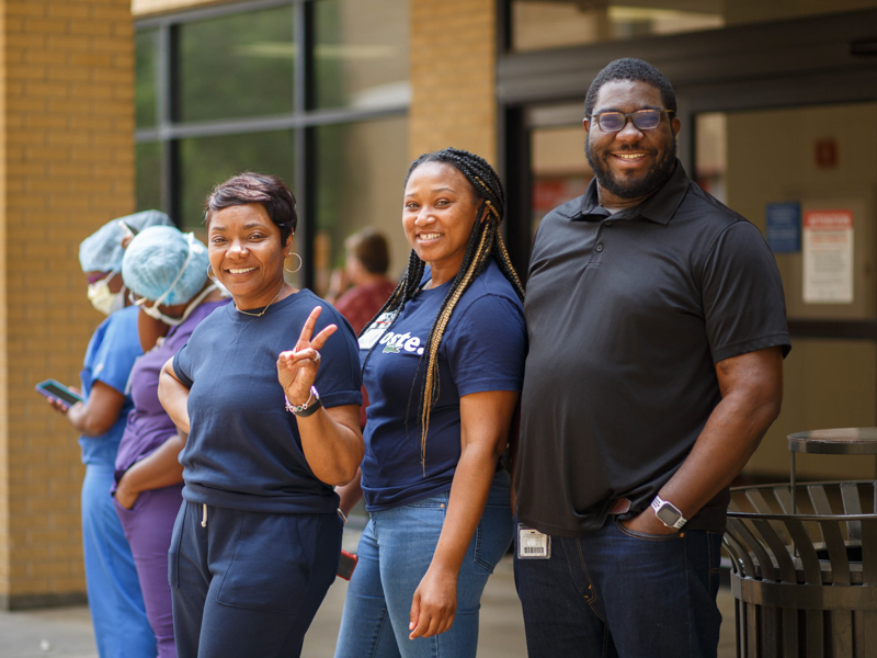 Billing specialists Debra Baker and Tasha Neal wait in a food truck line with patient access specialist James Anderson. Joe Ellis/ UMMC Communications