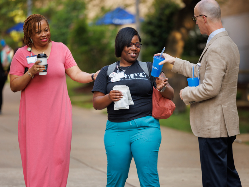Dr. Scott Rodgers, right, offers cups and other goodies to Ladonna Overton, left, manager of ambulatory operations, and certified medical assistant Janae Adams on the Guyton Breezeway during Employee Appreciation Week. Joe Ellis/ UMMC Communications