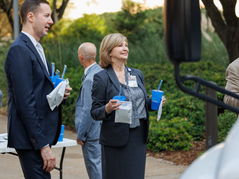 Brian Rutledge, left, Vice Chancellor for Health Affairs Dr. LouAnn Woodward and Dr. Scott Rodgers greet staff at the shuttle stop near the Learning Resource Center during Employee Appreciation Week. Joe Ellis/ UMMC Communications