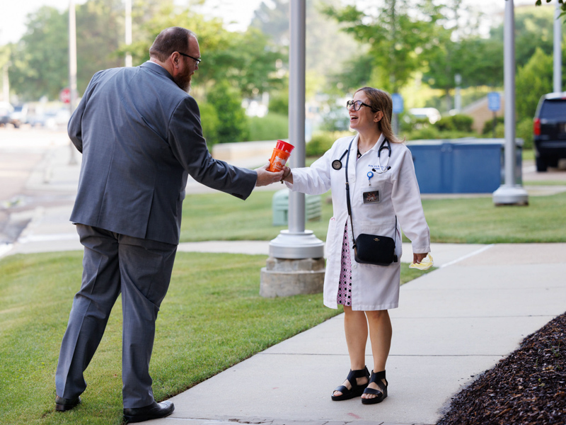 Chief Administrative Officer Jonathan Wilson offers a happy to Dr. Rola Abi Saleh near the Learning Resource Center. Joe Ellis/ UMMC Communications