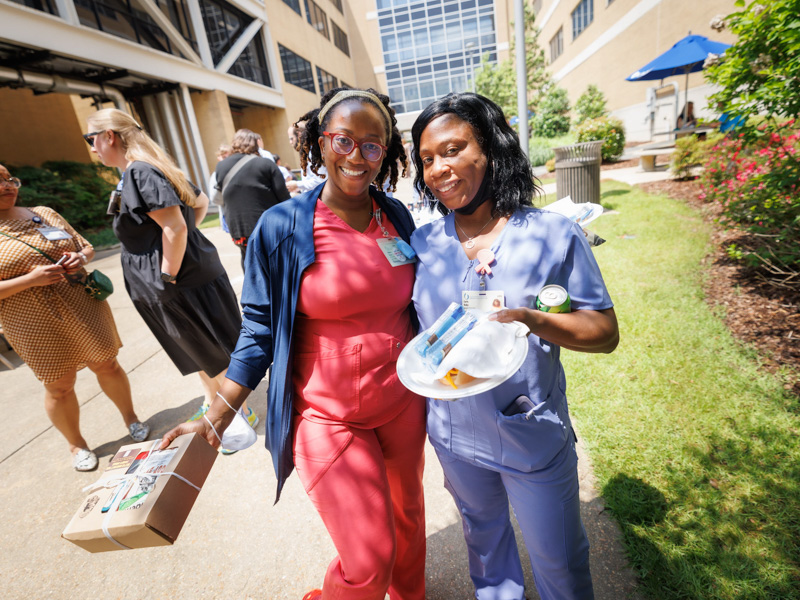 Registered Nurses Sebrina Brown, left, and Carla Roby, enjoy food and activities on the Guyton Building breezeway on Wednesday. Joe Ellis/ UMMC Communications 