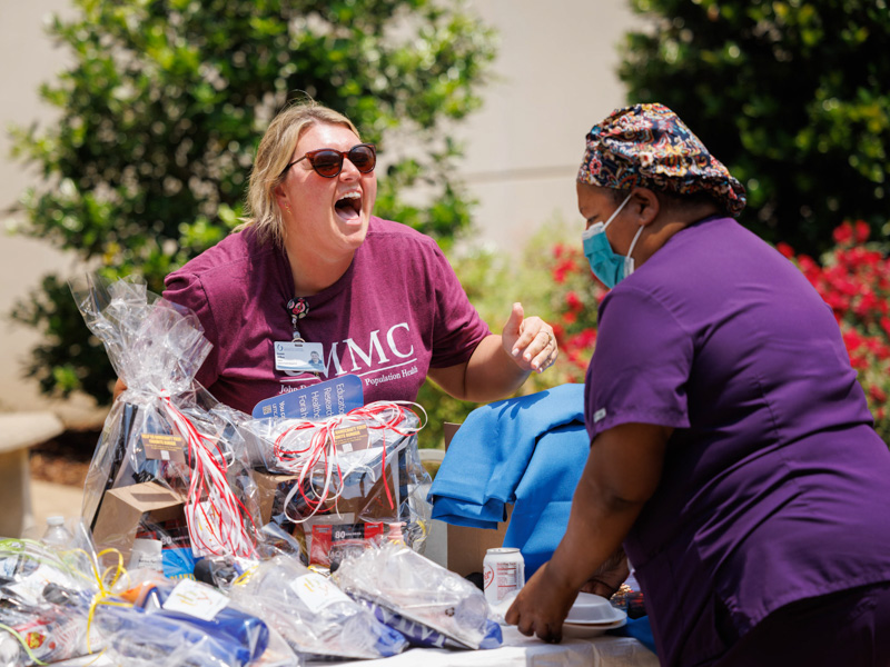 Jeanna Wilkes, director of educational operations with the John D. Bower School of Population Health, and nurse educator Dorothy Aultman-Abrams visit in the Guyton Breezeway Wednesday during Employee Appreciation Week. Joe Ellis/ UMMC Communications