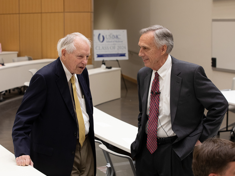 Hall, right, greets 2021 honoree Dr. Kenneth Bennett, professor emeritus of medicine, before Hall's presentation April 26.