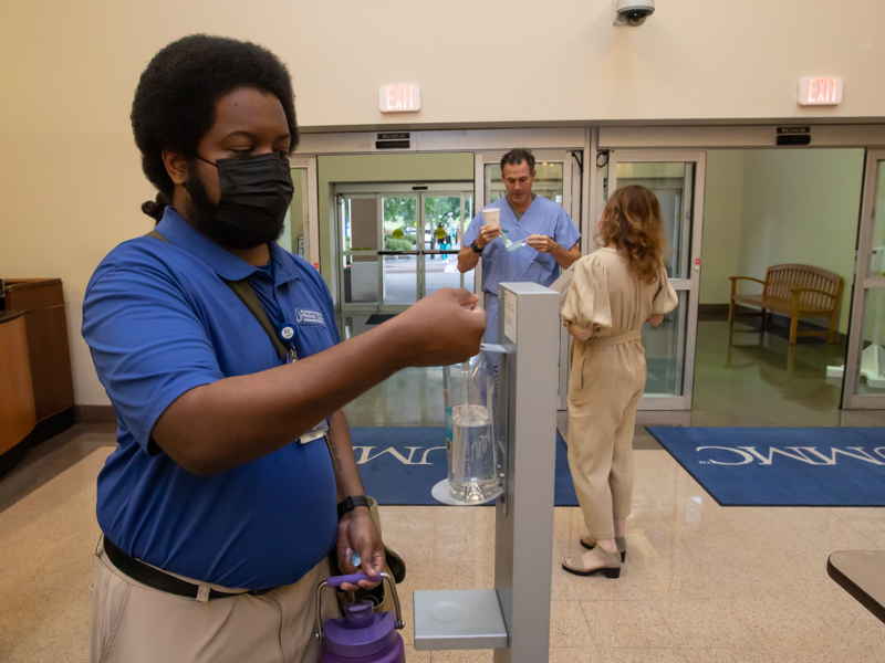 University Hospital ambassador Trevor Dukes uses hand sanitizer at the University Hospital entrance. Melanie Thortis/ UMMC Communications 