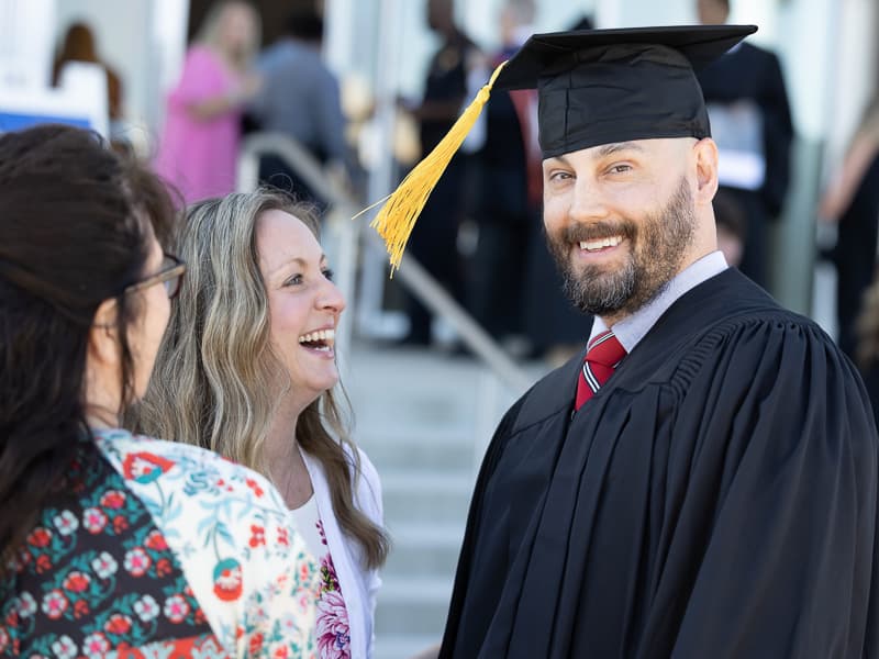 Melody Grey and her husband, Garrett Grey, share a laugh prior to commencement.