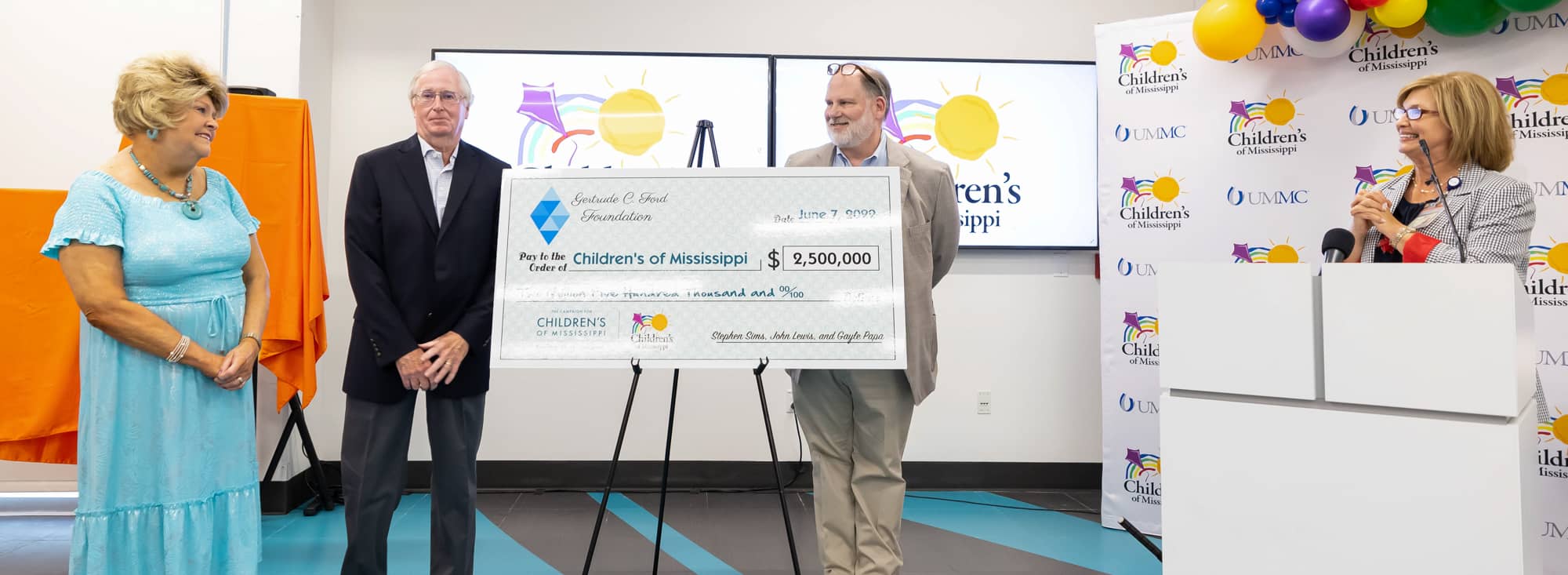 Gertrude C. Ford Foundation President Cheryle Sims, left, and Dr. LouAnn Woodward, vice chancellor for health affairs and dean of the School of Medicine, watch as Stephen Sims, director of the foundation, and John Lewis, vice president and treasurer of the foundation, unveil a $2.5 million donation. Melanie Thortis/ UMMC Communications