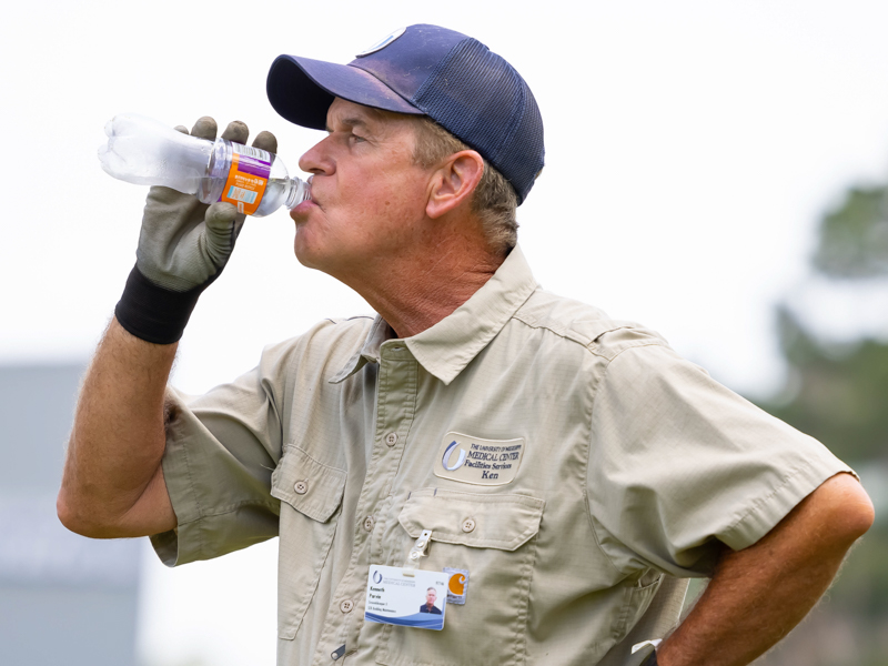 Kenneth Parvin, a groundskeeper with the UMMC's Facility Services, takes breaks from weed-eating to hydrate. Melanie Thortis/ UMMC Communications