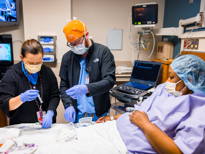 Registered nurse Karen Hughes and Dr. Justin Mahaney, an anesthesiology resident, help prepare Tawanna Davis for her kidney transplant surgery. Lindsay McMurtray/ UMMC Communications