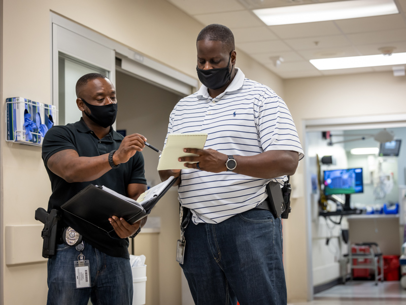 Officers Garry Lee and Sharkey Ford of the behavior response team discuss a patient's follow-up visit in the hospital. Jay Ferchaud/ UMMC Communications