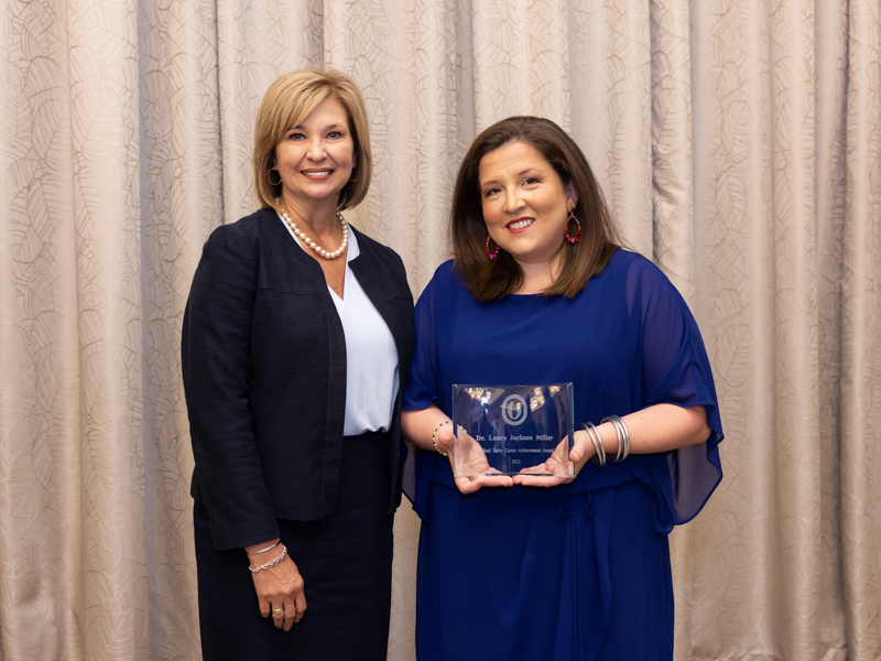 Dr. LouAnn Woodward, left, applauds Dr. Laura Jackson Miller, winner of the 2022 Early Career Achievement Award. Jay Ferchaud/ UMMC Communications