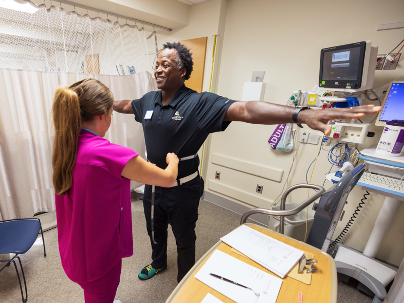 School of Nursing student Kristen Bailey measures the waist of former NFL player Stacy Siran of Nashville as part of free health evaluations Saturday at University Heart. Melanie Thortis/ UMMC Communications 