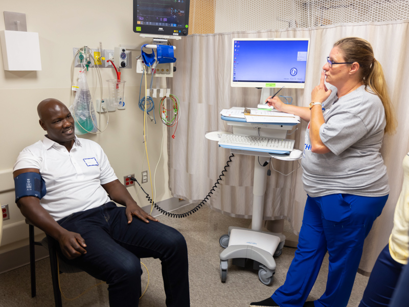 School of Nursing student Kirschen Craft jokes with former NFL player Torrence Small of New Orleans while she takes his blood pressure at University Heart. Melanie Thortis/ UMMC Communications
