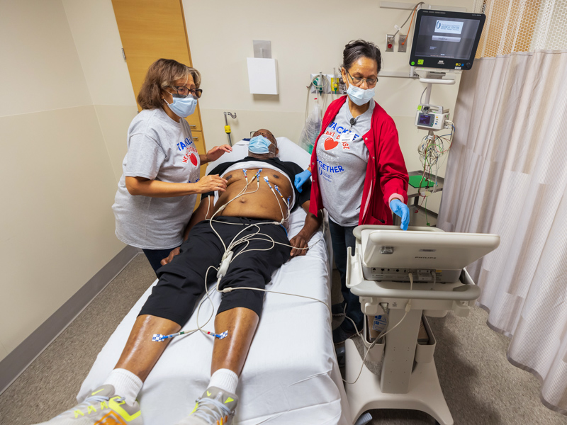 From left, cardiologist Dr. Myrna Alexander Nickens and certified medical assistant Robbie Moore perform an electrocardiogram on former NFL player Lawrence Pillers of Jackson. Melanie Thortis/ UMMC Communications 