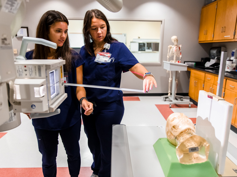 Radiologic Sciences students Mallory Hunt, left, and Kaitlyn Newell measure while setting up an x-ray during a lab.