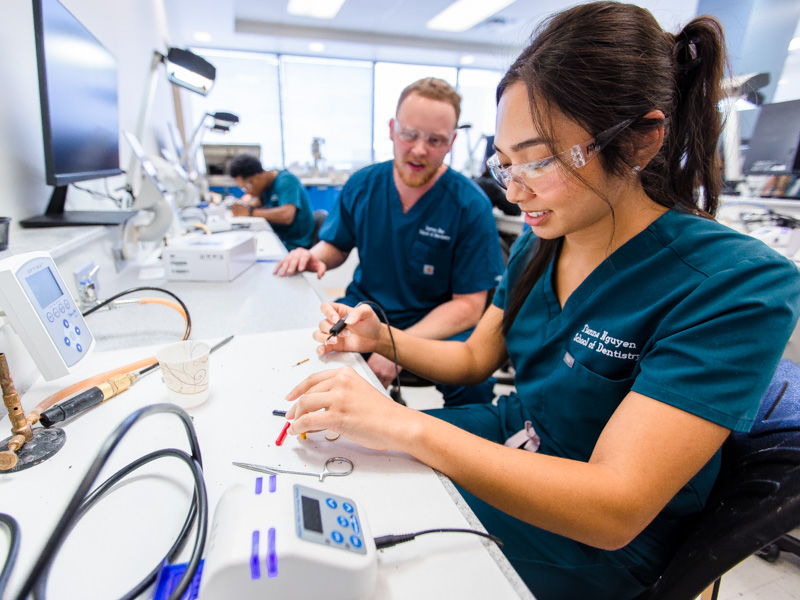 First-year School of Dentistry students Dutton Day and Tianna Nguyen compare notes on the unique creations they're making from melted wax as part of a laboratory exercise.