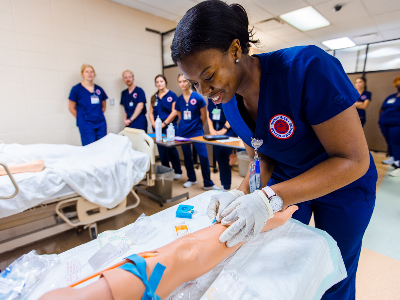 School of Nursing student Maya Anderson inserts a peripheral IV into a manikin arm as part of the school’s skills relay exercise, held in August at UMMC’s Simulation and Interprofessional Education Center in the Medical Education Building. The school recorded an enrollment rise of 4 percent for the fall, second-highest rate among campus schools.