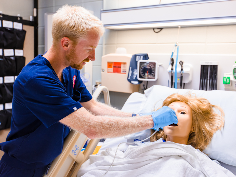 Nursing student Quinn Chandler inserts a nasogastric tube during a training exercise at the School of Nursing.