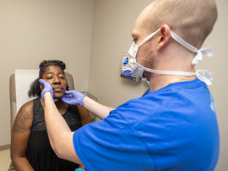 Oral Surgery resident Dr. Matthew Russ gives an oral health screening to patient Michelle Wilson during the See, Test and Treat event held at the Jackson Medical Mall. Melanie Thortis/ UMMC Communications