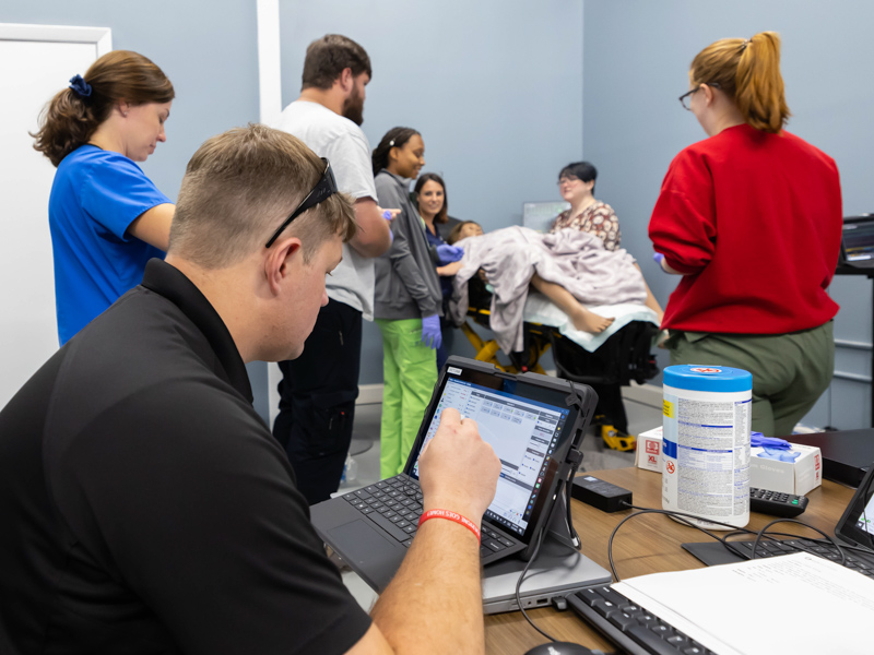 Will Appleby, transport educator with the Mississippi Center for Emergency Services, controls a STORK training simulation from his laptop. Melanie Thortis/ UMMC Communications