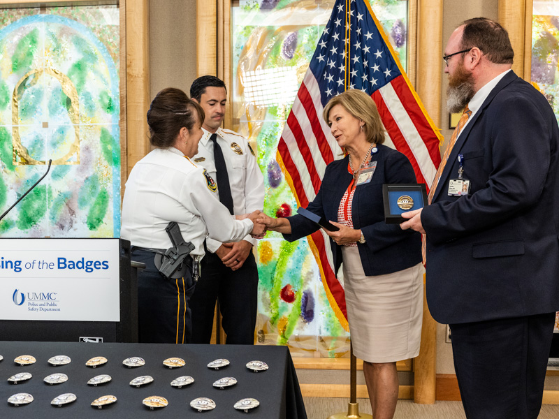 UMMC Police and Public Safety Department Chief Mary Paradis, left, and Deputy Chief Josh Bromen accept thanks from Dr. LouAnn Woodward, vice chancellor for health affairs and dean of the School of Medicine, and Chief Administrative Officer Dr. Jonathan Wilson. Jay Ferchaud/ UMMC Communications 