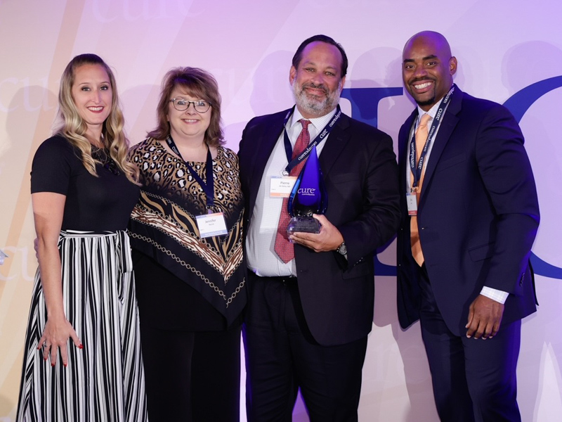 Dr. Pierre de Delva, third from left, accepts his Lung Cancer Heroes award Friday in Chicago with CURE magazine’s Kristie Kahl, Jennifer Myrick, senior manager of cancer support strategic partnerships for the American Cancer Society and former NFL player Chris Draft in attendance.