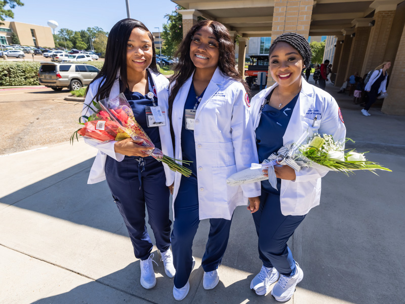Wearing their new white coats are nursing students, from left, Khelsia Waters, Kiyah Brown and Aliyah Cubit smile after the School of Nursing's combined white coat and honor code ceremony.