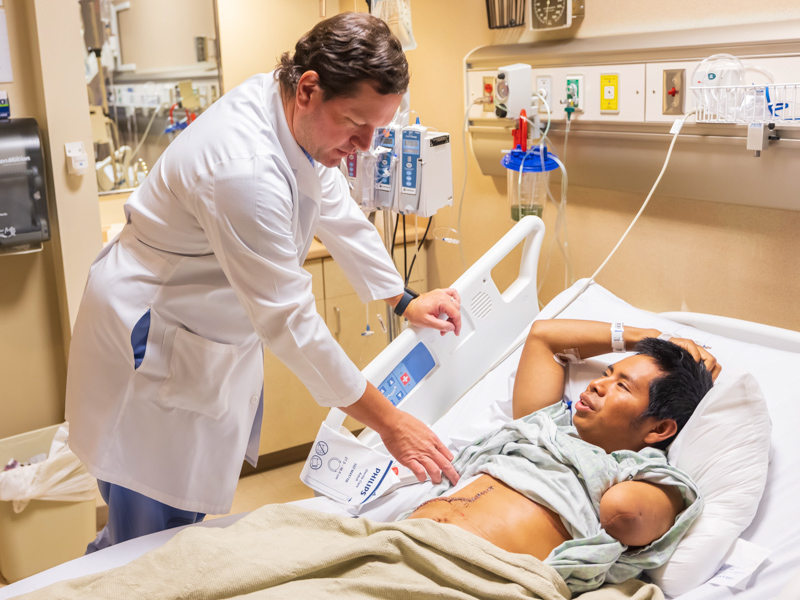 Dr. Shannon Orr, associate professor of surgery, examines the incision of Moss Point resident Geremias Lux Pu before discharging him following his Oct 20 abdominal intraoperative radiation therapy, or IORT, procedure. Melanie Thortis/ UMMC Communications