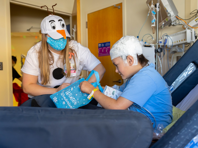 "Olaf," aka child life specialist Courtney Easterday, shares a wintry treat with Children's of Mississippi patient William "Chase" Winters of Cleveland. Melanie Thortis/ UMMC Communications