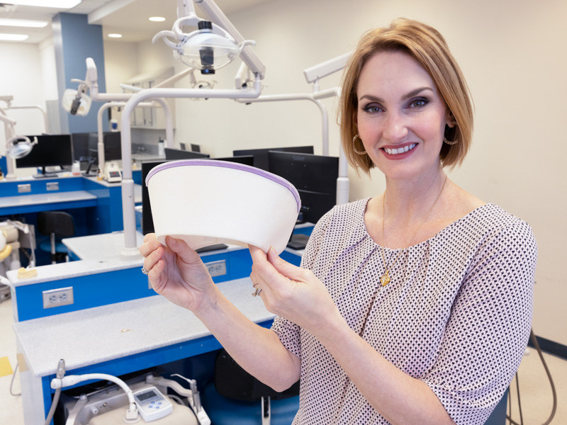 Dr. Elizabeth Carr, professor and chair of the Department of Dental Hygiene in the School of Dentistry and a 2000 SHRP dental hygiene program grad, displays the cap worn by early graduates of the 50-year-old program. Jay Ferchaud/ UMMC Communications 