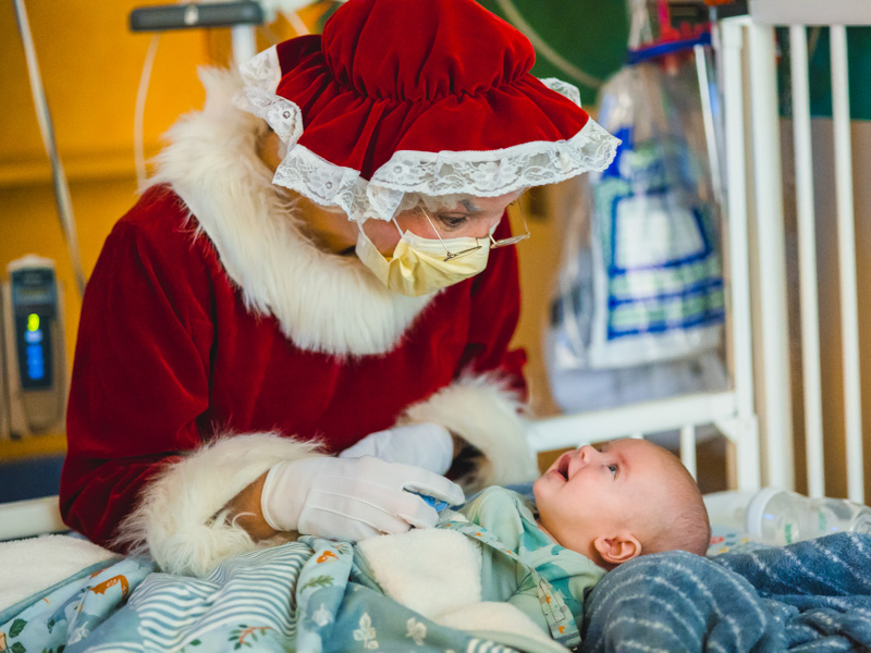 Mrs. Claus looks at Children's of Mississippi patient Alexander James Wegner of Perkinston during Santa's annual visit to the hospital. Lindsay McMurtray/ UMMC Communications 