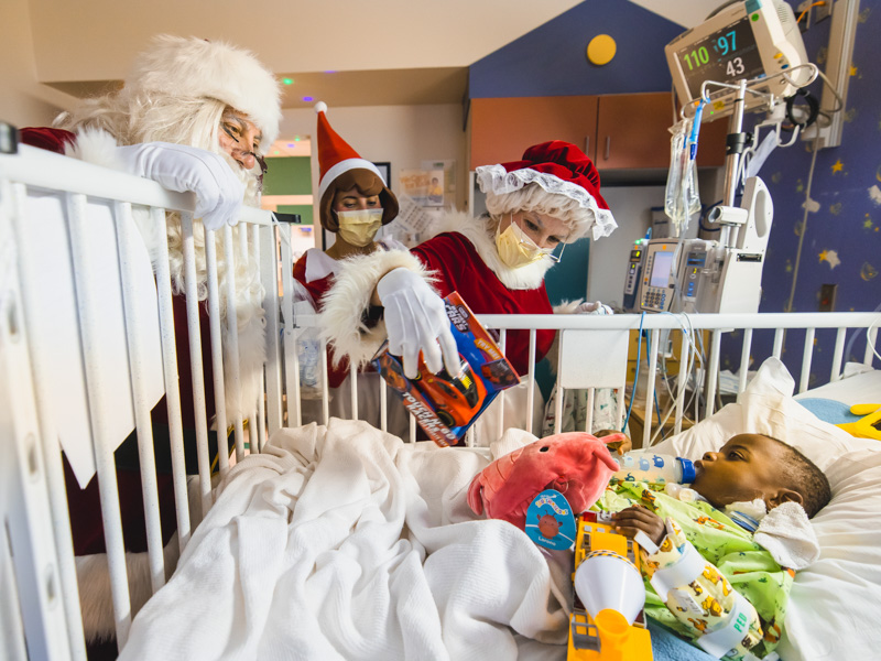 Santa, Mrs. Claus and their elf deliver gifts to Children's of Mississippi patient Logan Jackson of Brookhaven. Lindsay McMurtray/ UMMC Communications 