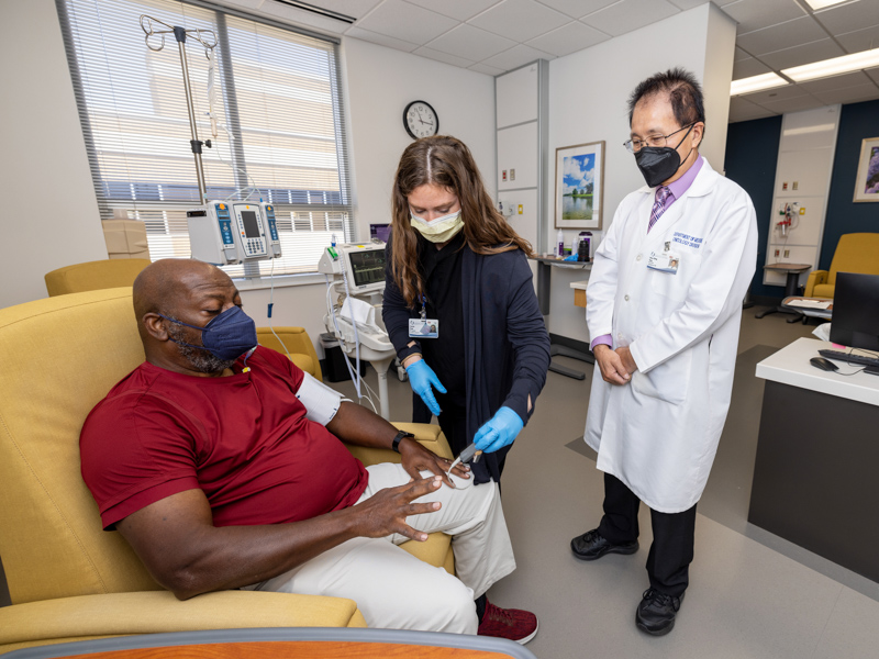 Thomas Hopkins, seated left, of Bolton, is examined by registered nurse Serena Flynt as part of a clinical trial conducted by Dr. Shou-Ching Tang, right. Jay Ferchaud/ UMMC Communications 