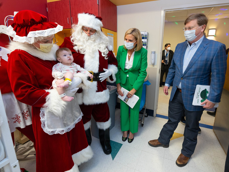 Children's of Mississippi patient Naomi Steen, in Mrs. Claus' arms, enjoys a visit by her, Santa Claus and First Lady Elee Reeves and Gov. Tate Reeves. Jay Ferchaud/ UMMC Communications 